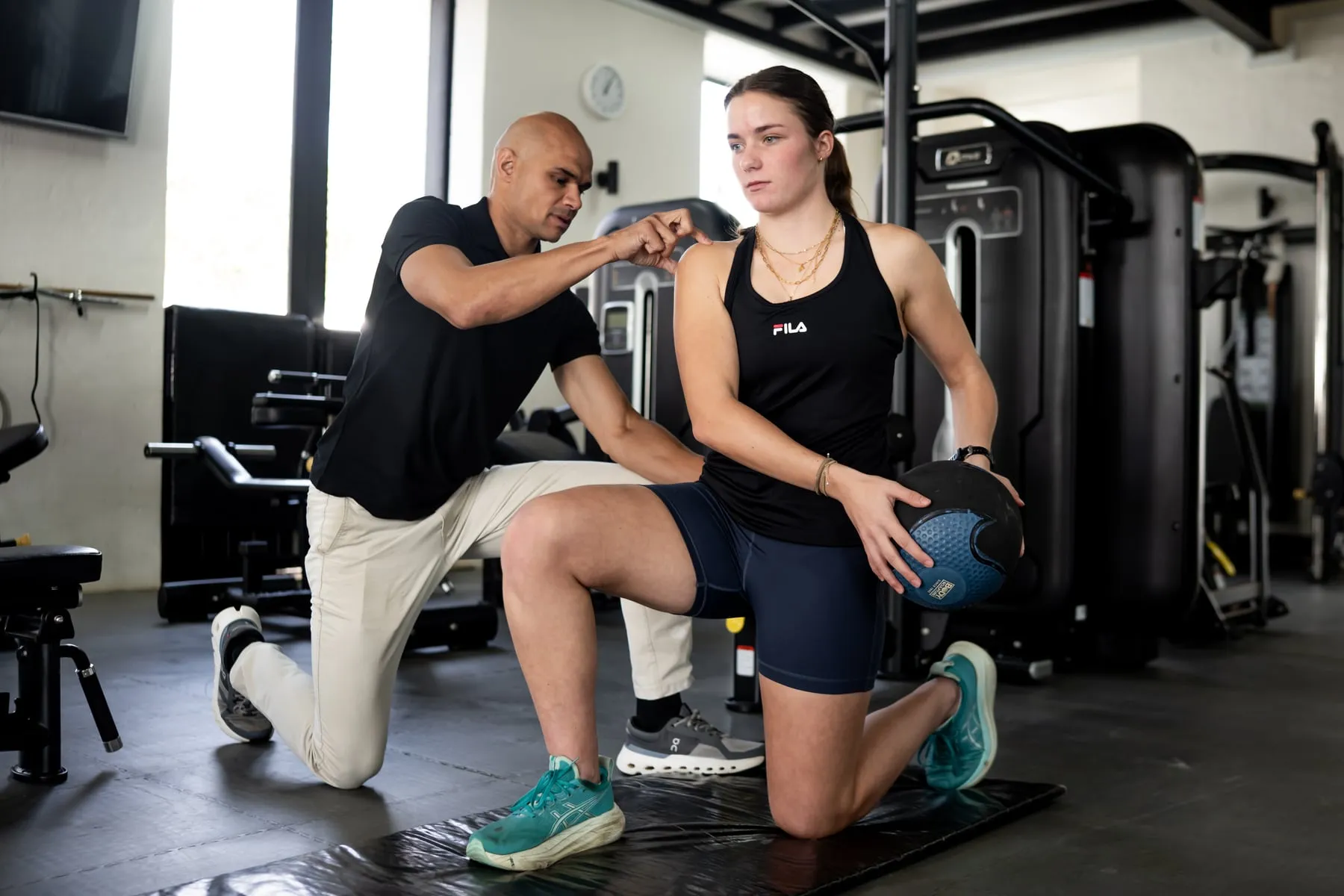 A Movewell clinician coaching an athlete through a medicine-ball exercise